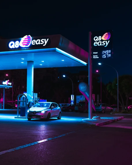 a gas station with the neon light of cars coming out