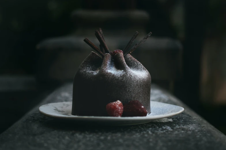 small plate with a chocolate cake and strawberries on it