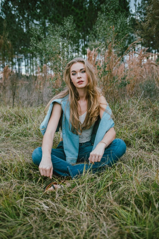a girl sits on a patch of grass
