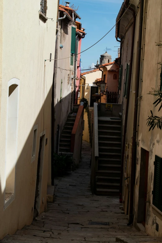 narrow alleyway with stairs between two buildings