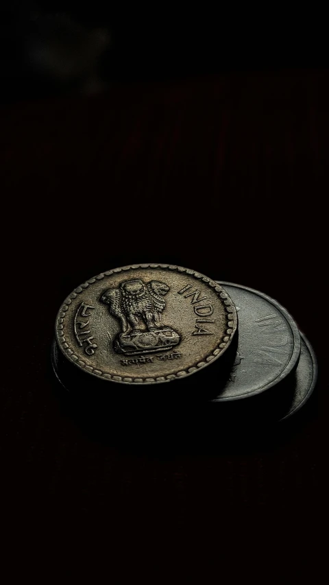 three coins are sitting on a black surface