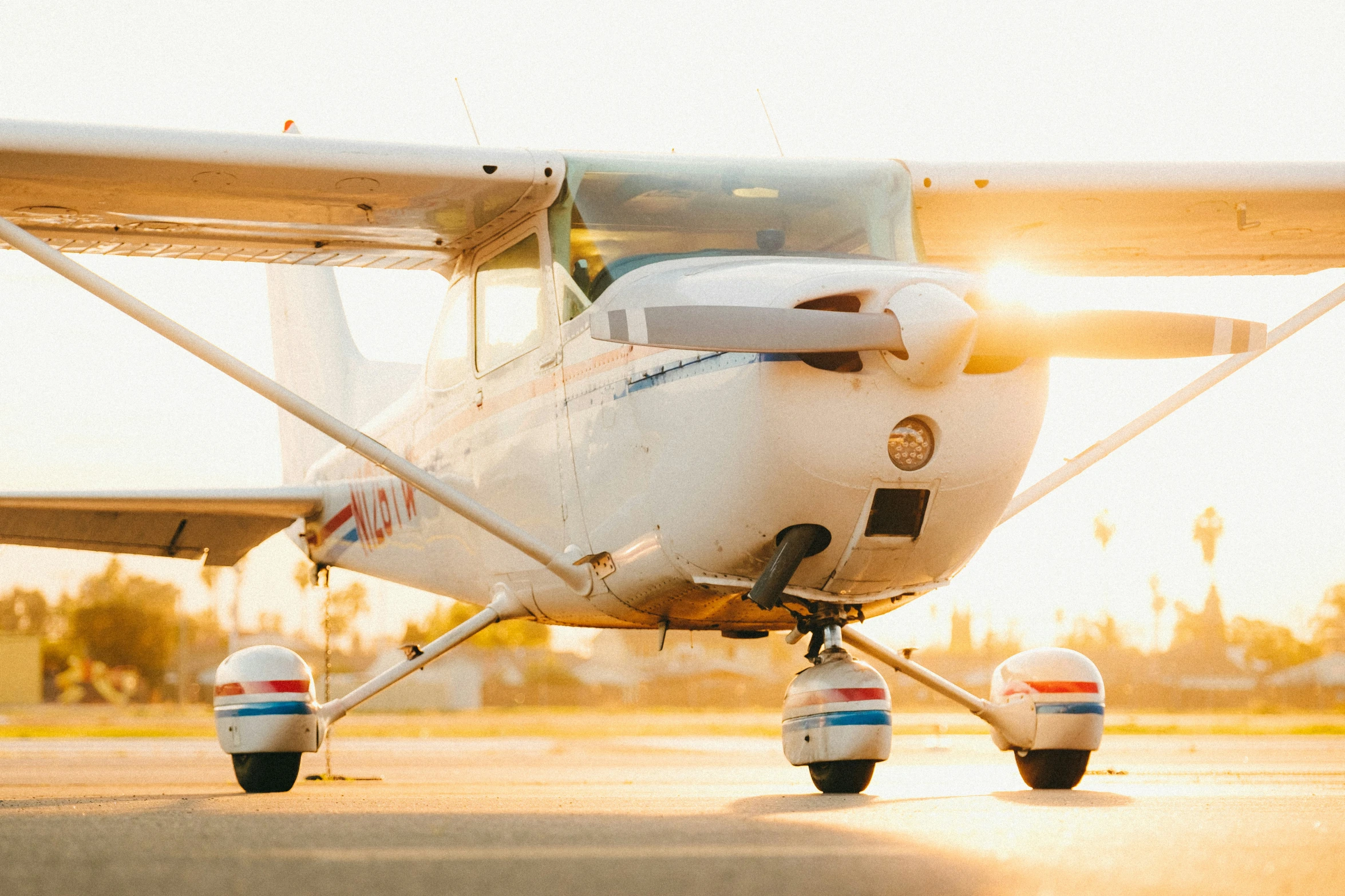 the white propeller airplane sits on the tarmac