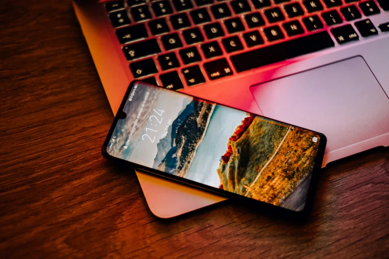 a cellphone sits in front of a keyboard on a table