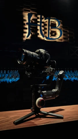 a camera sitting on a tripod in front of a logo