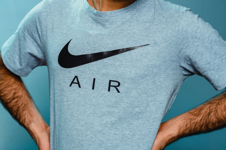 a man with his hands on his hips and a nike t - shirt