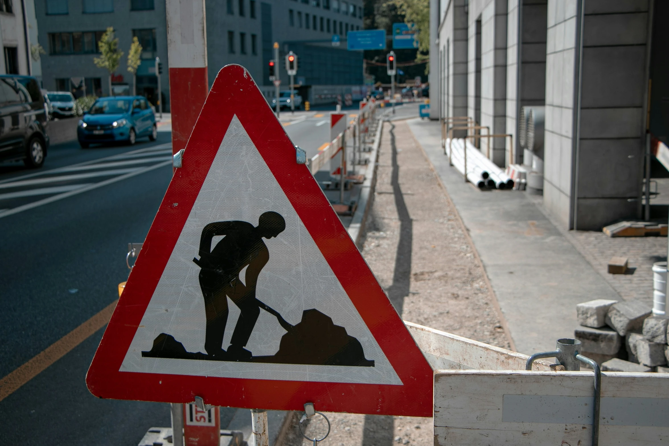 a red triangular triangle sign with a man working