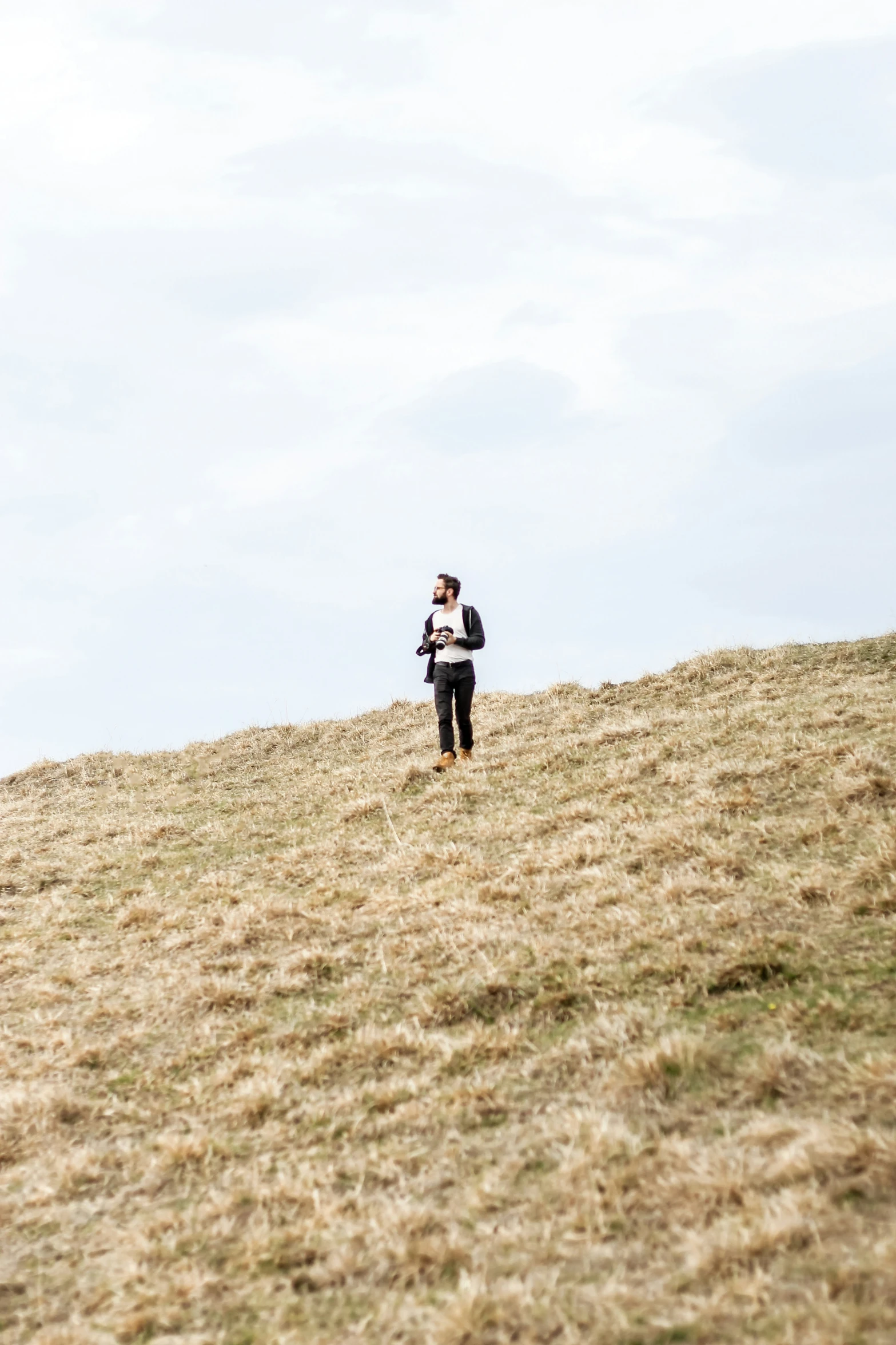 the man is on the hill preparing to fly a kite