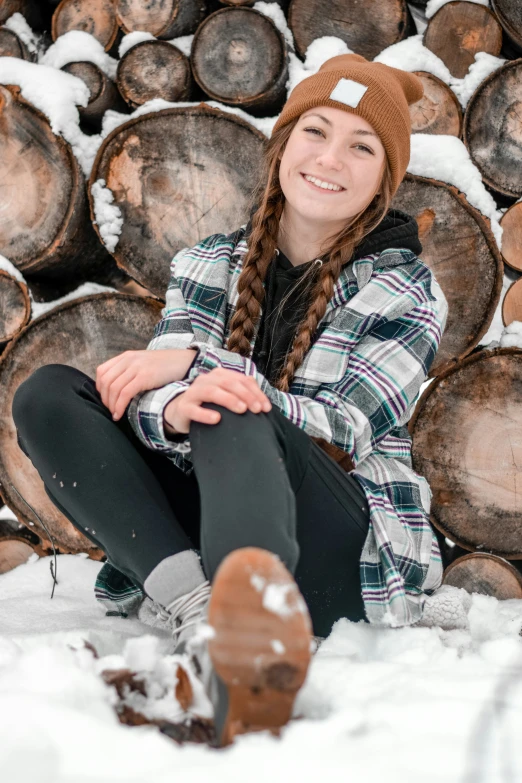 a person wearing a beanie is sitting in the snow