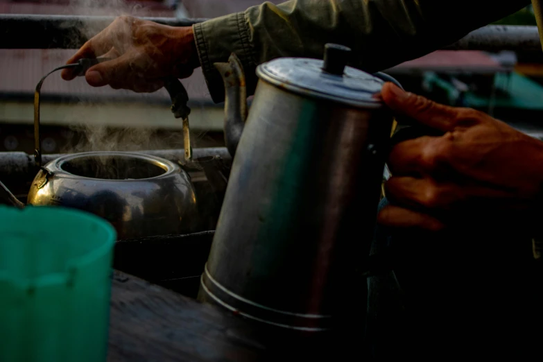 a person cooking over a tea kettle near the road