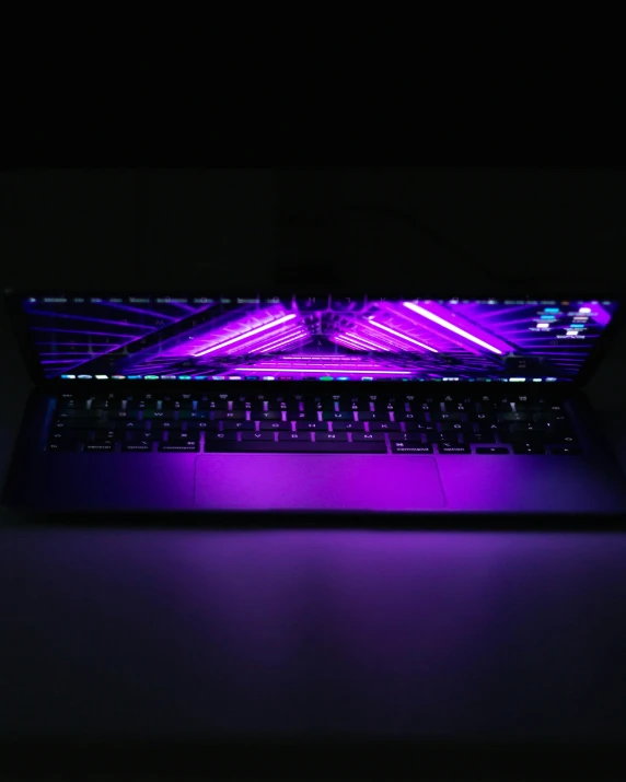 an empty laptop computer lit up with purple lighting