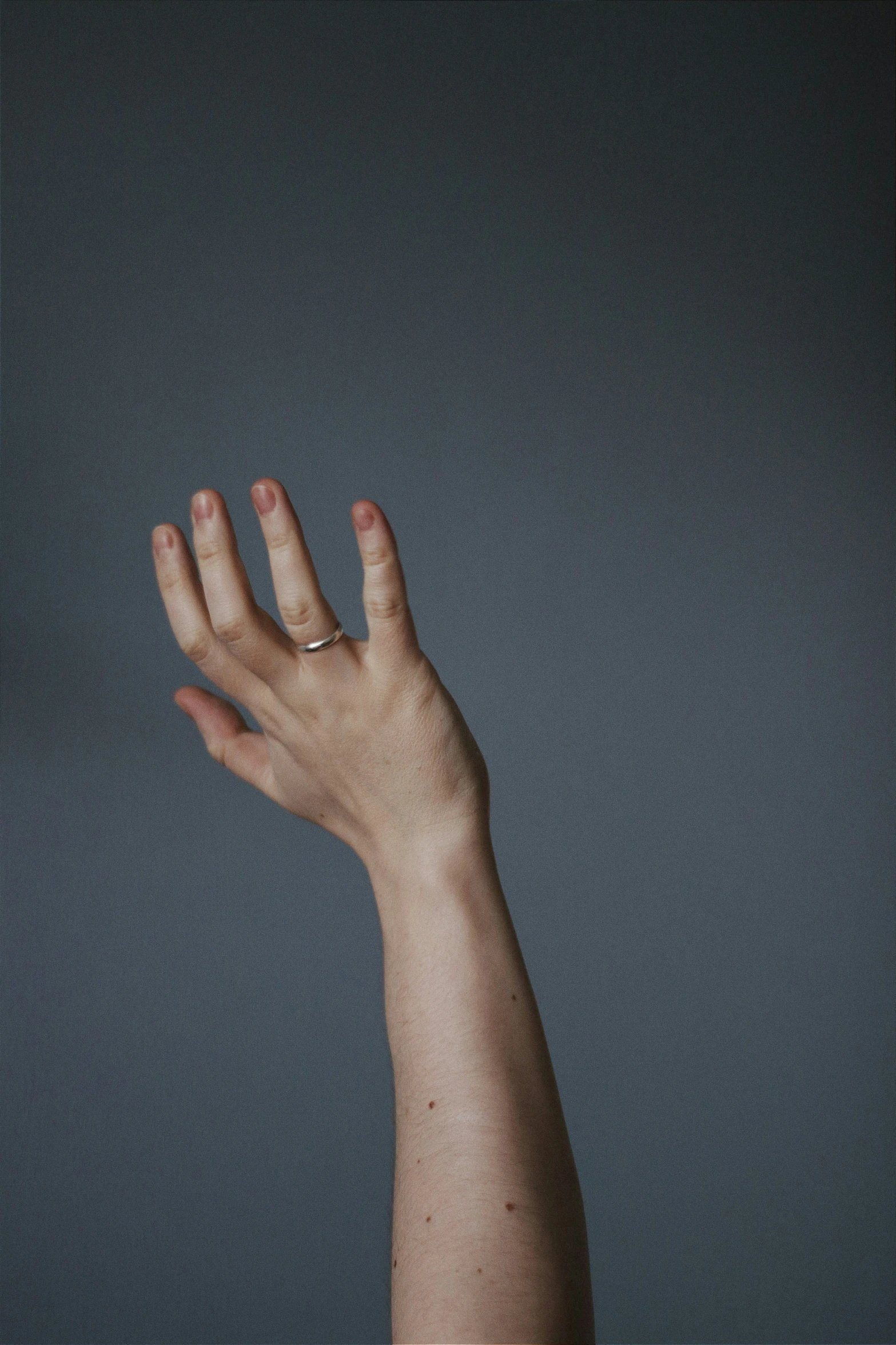 a person's hand reaching up into the air