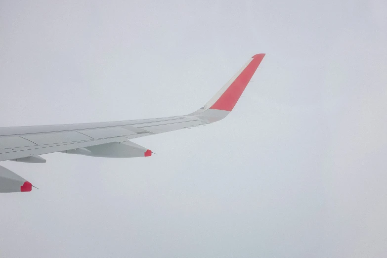 a large airplane flying through a gray sky