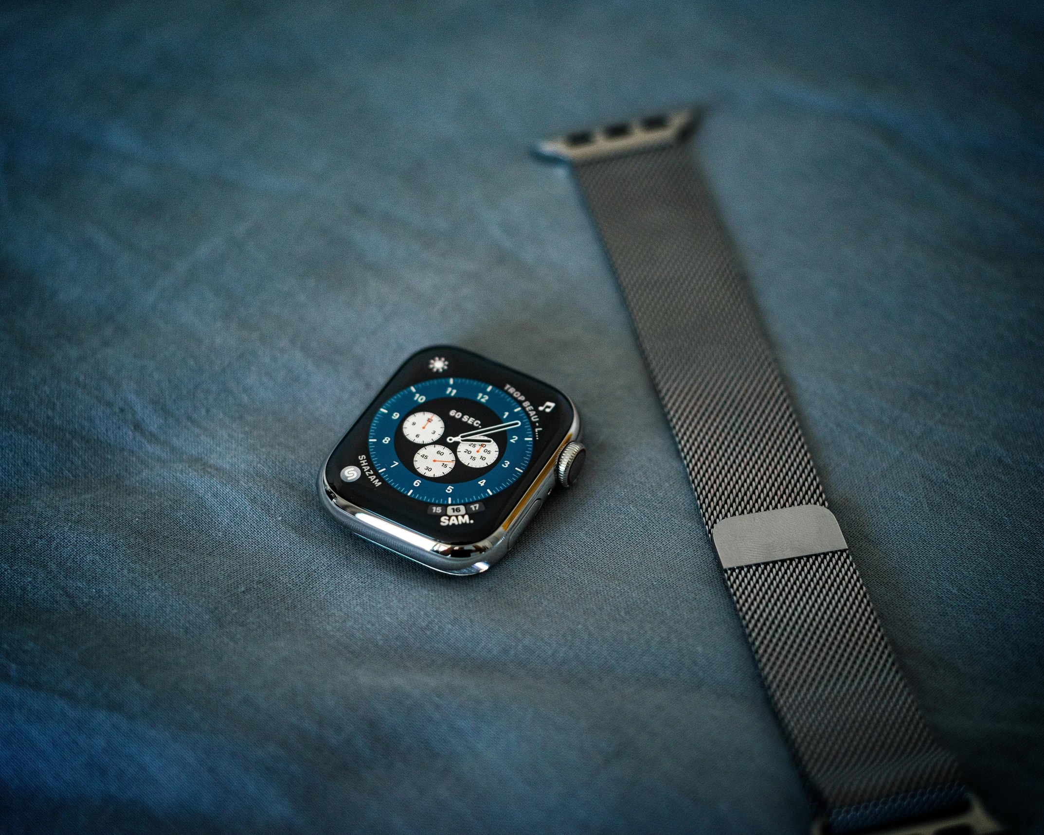 an apple watch is laying on blue jeans