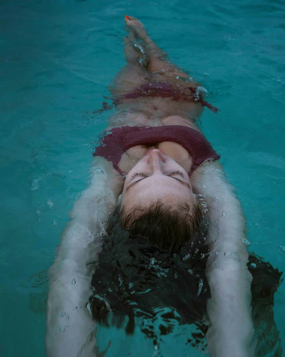 a man in red shirt swimming in the water