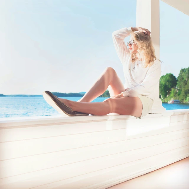 a woman sitting on the edge of a wooden platform with her feet up on a ledge