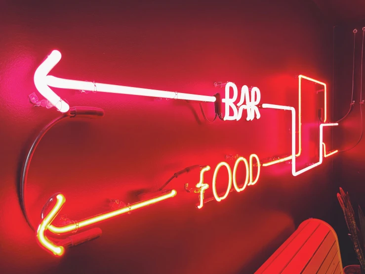 red neon sign and arrows with white letters pointing in opposite directions