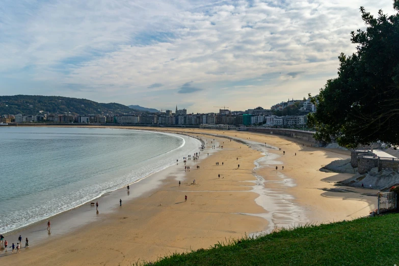 people are swimming at the water's edge on a beach