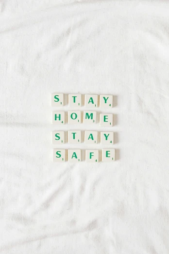 four scrabble type words sitting on a white blanket