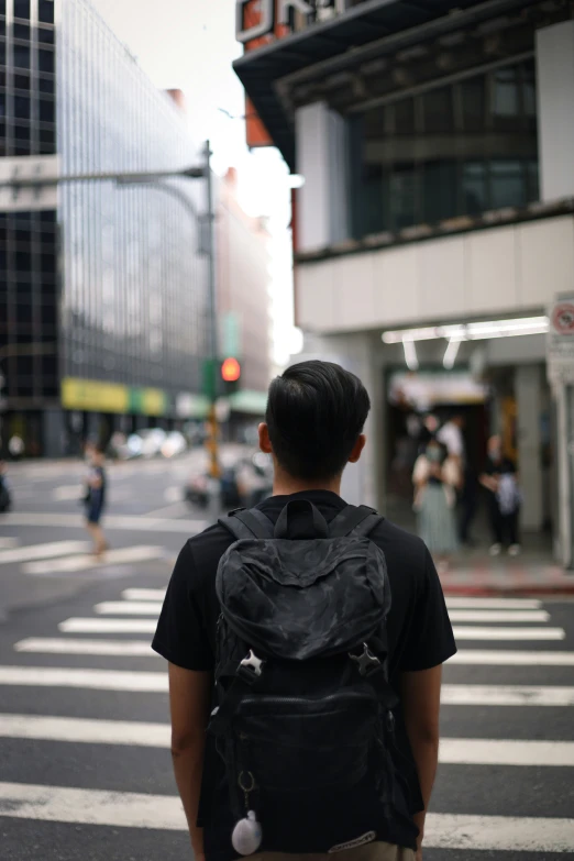 a person wearing a backpack while crossing the street