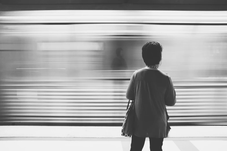 a person standing in front of a train and a blurry background