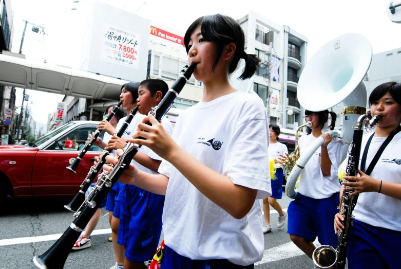 girls in uniform marching down the street with their instruments