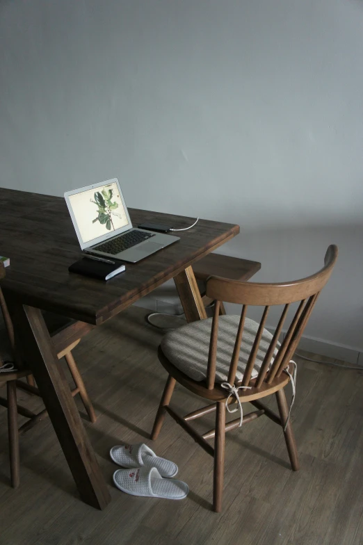 the laptop is next to some wood chairs