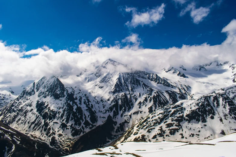 a snowboarder is jumping over a mountain during a snowy day