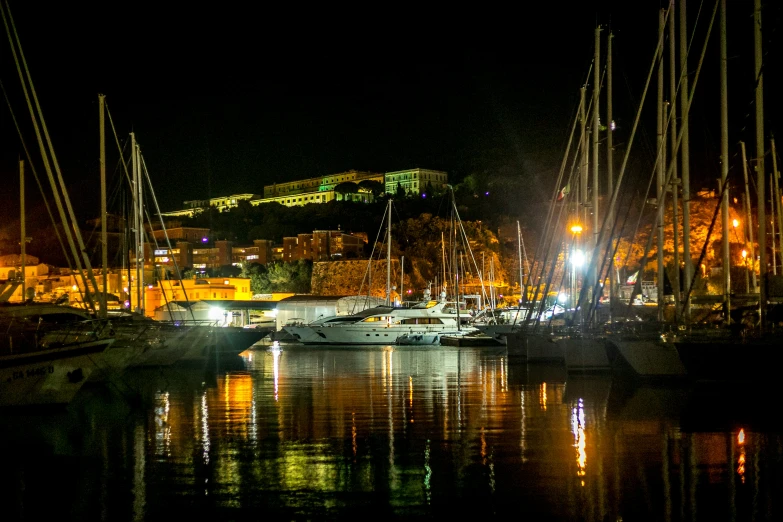 boats in a harbor in the city at night