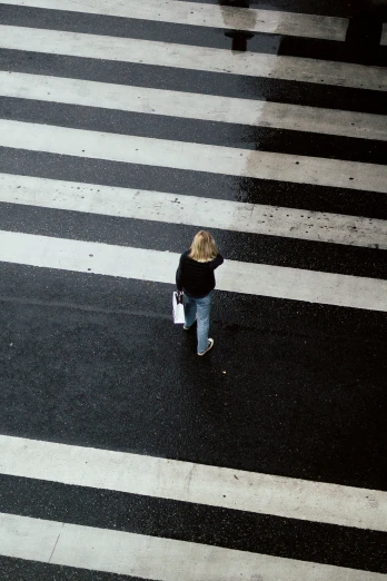 an aerial s of a person on their cell phone walking across a crosswalk