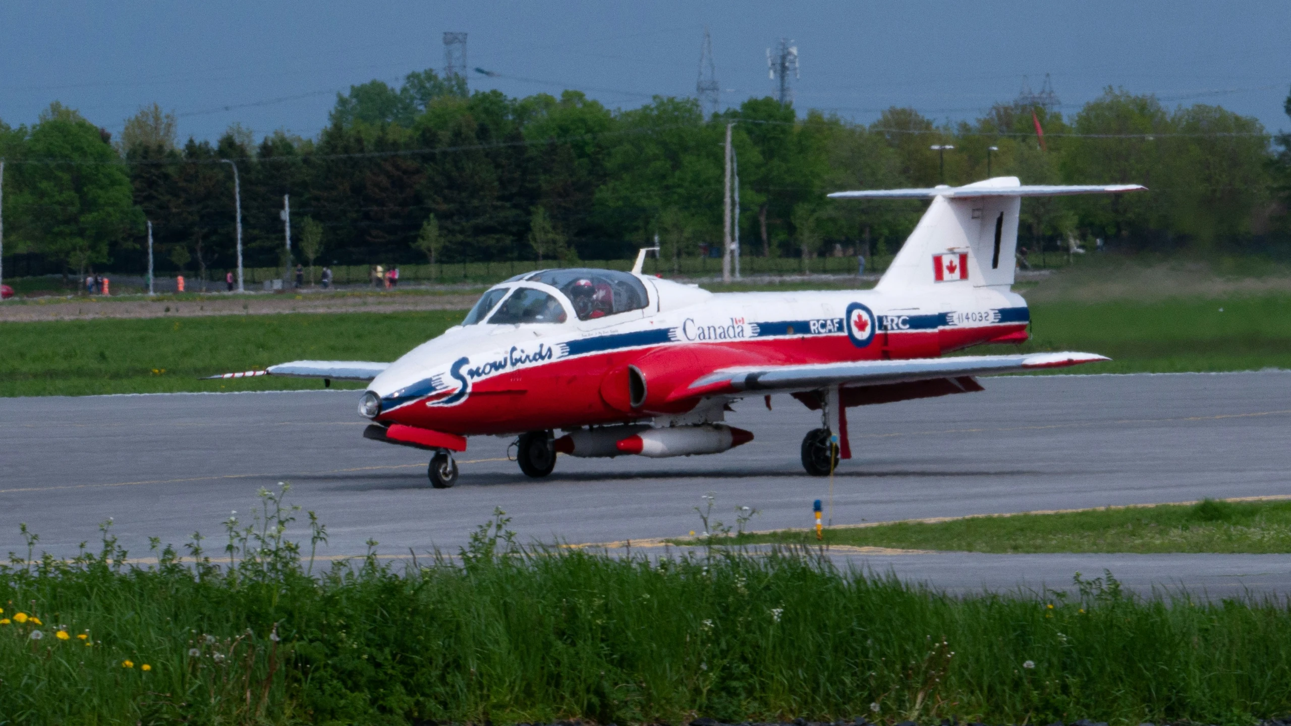 a small red and white plane sitting on a tarmac