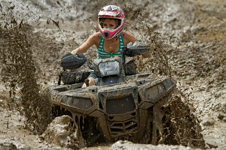 girl with helmet on a muddy dirt bike