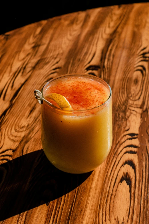 a glass filled with liquid and sitting on top of a table