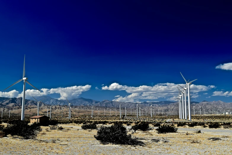 a row of wind turbines in the middle of a desert