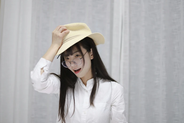 an asian woman wearing glasses and a hat