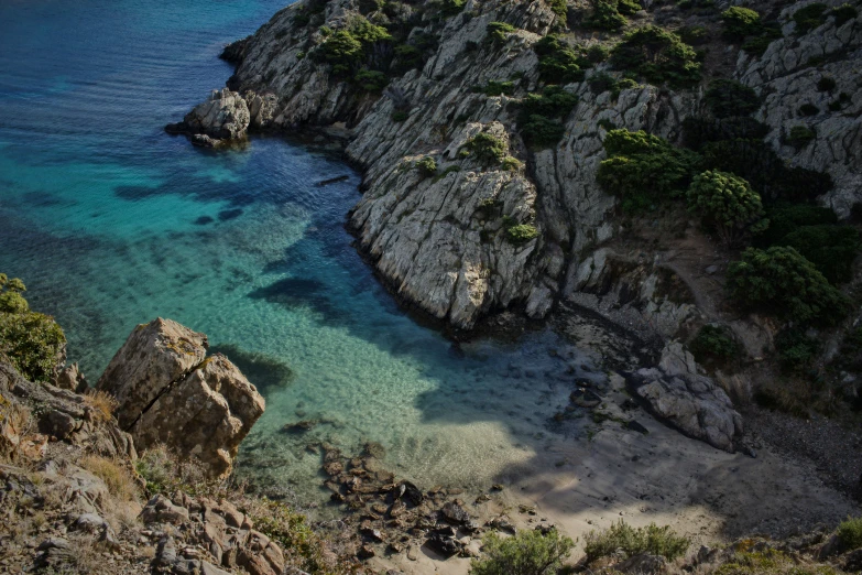 a rocky cliff with clear water surrounded by rocks