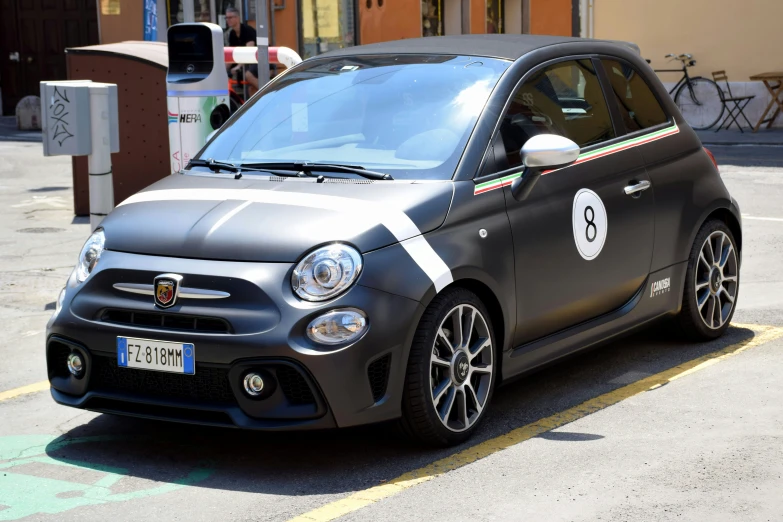 a black smart car is parked on the side of a street