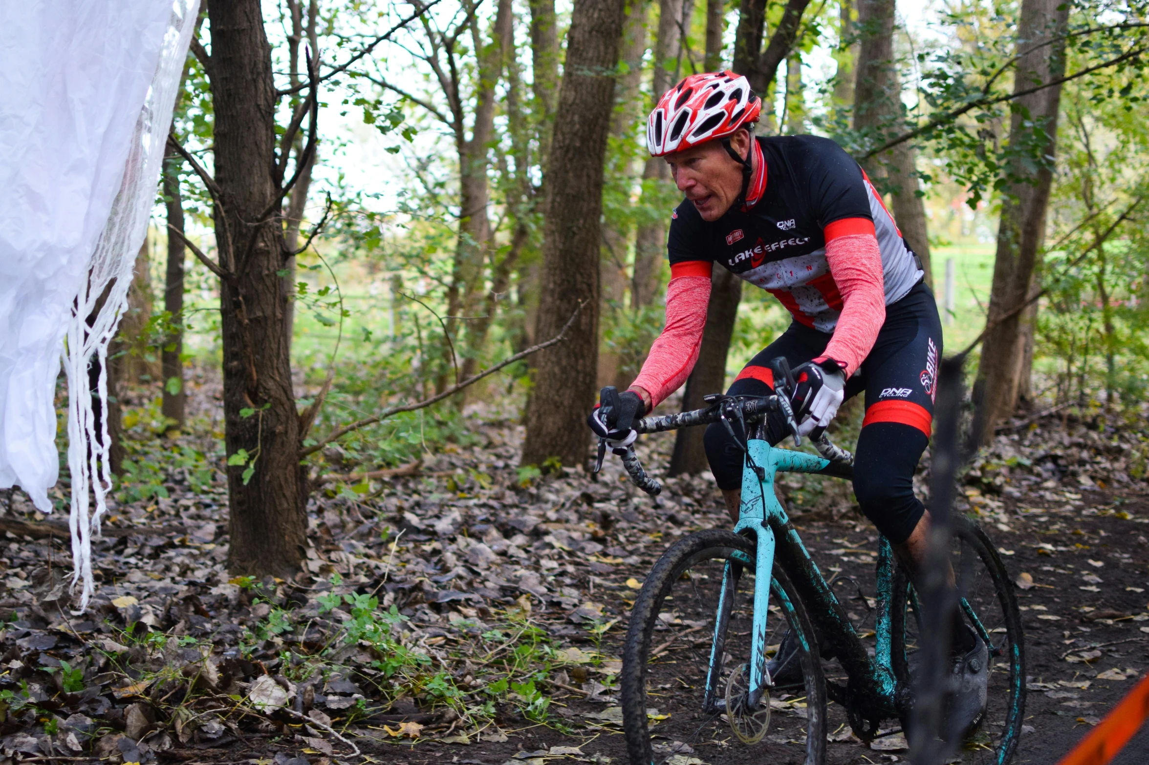 a man riding a bicycle down a trail through trees