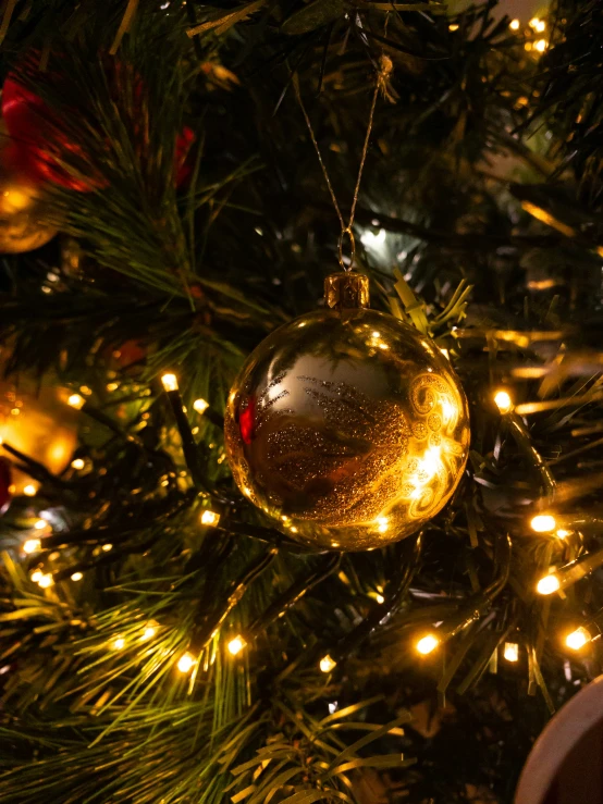 a yellow ornament hanging from the tree