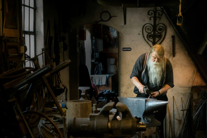 an old man with a long beard is carving soing