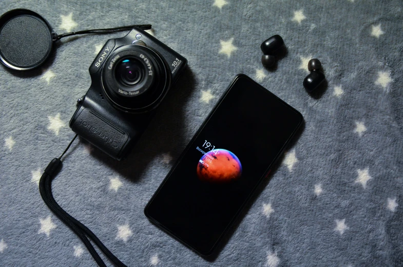 there is an iphone that is on the table next to a camera