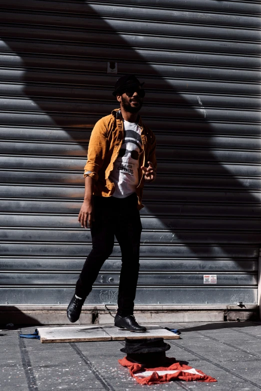 a man stands on a skateboard near the wall