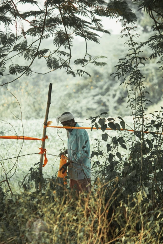 a man holding onto a stick in the woods