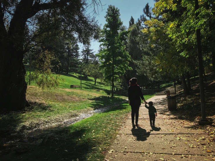 a person walking with a child down a path