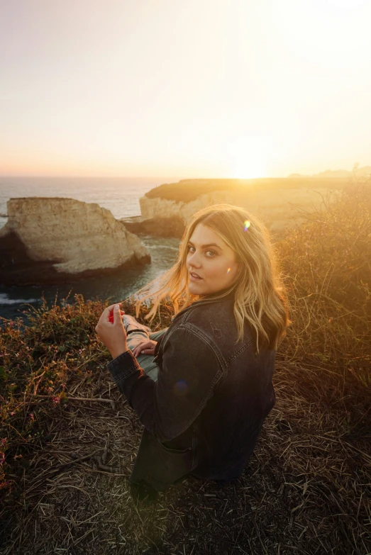 woman taking selfie with her cell phone, near the ocean