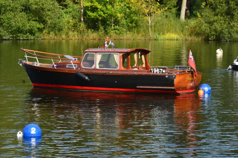 a black and red boat floating in a body of water