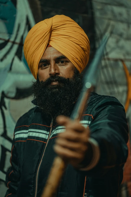 a man with a turban holding a stick