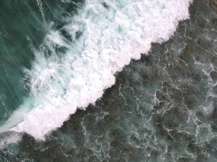 an aerial view of the ocean with two surfers