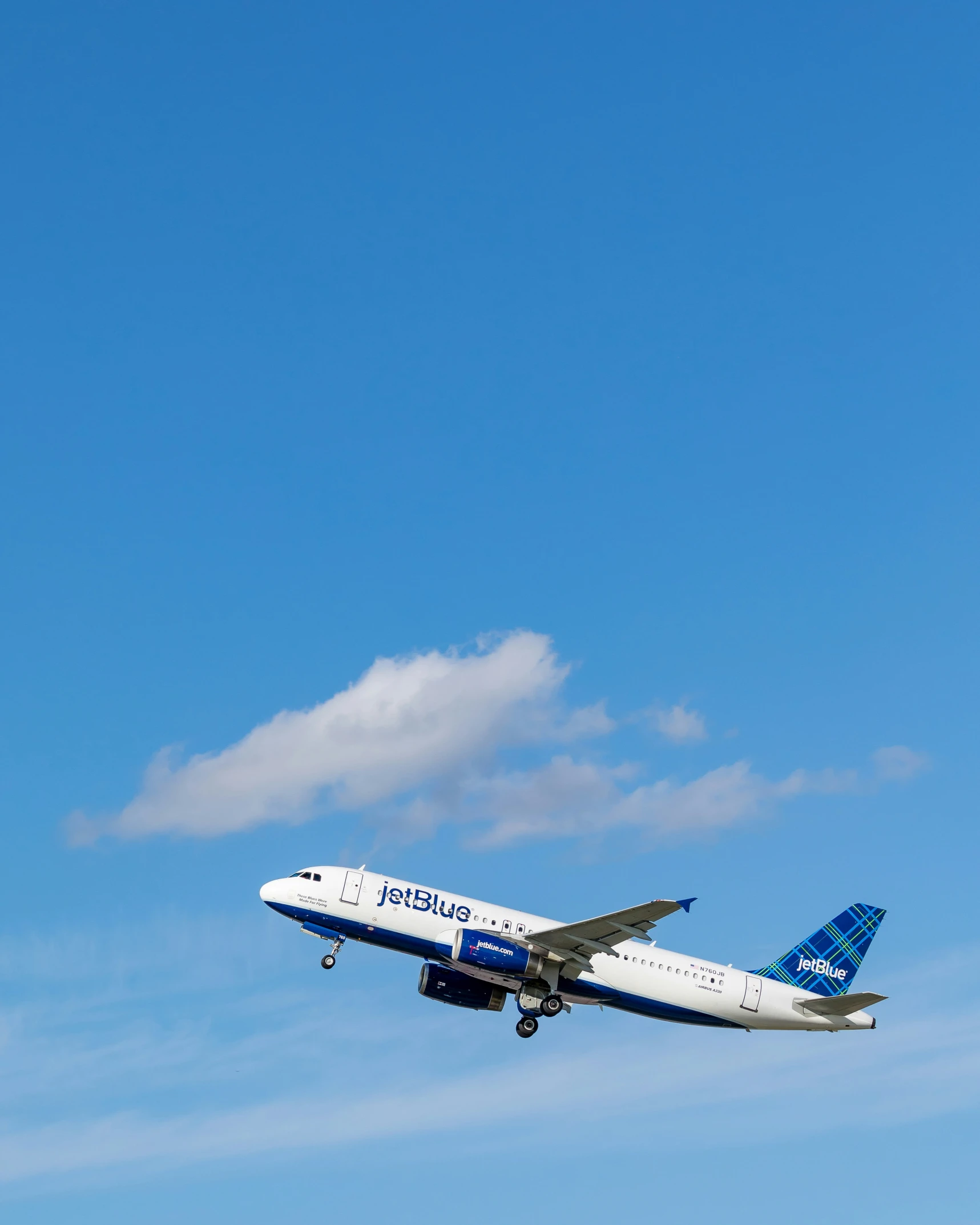 a large white and blue jet airplane flying in the sky