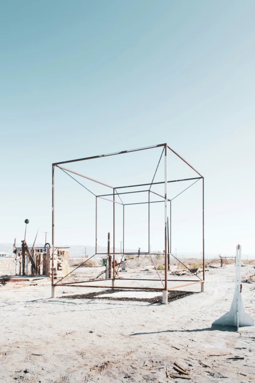 a broken sculpture sits on the dirt near the ocean