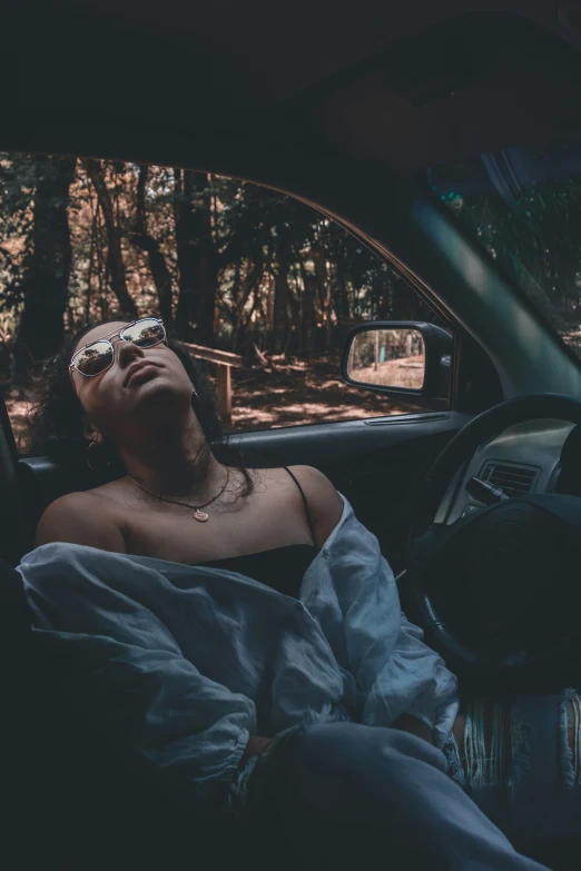 a woman sitting inside of a car while sleeping